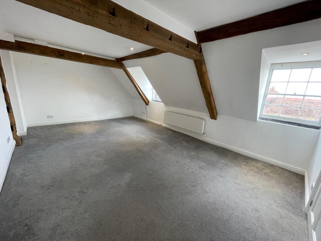 Lot: 90 - VACANT TOP FLOOR FLAT WITH VIEWS OVER SURROUNDING AREA - living room with exposed beams and windows to front